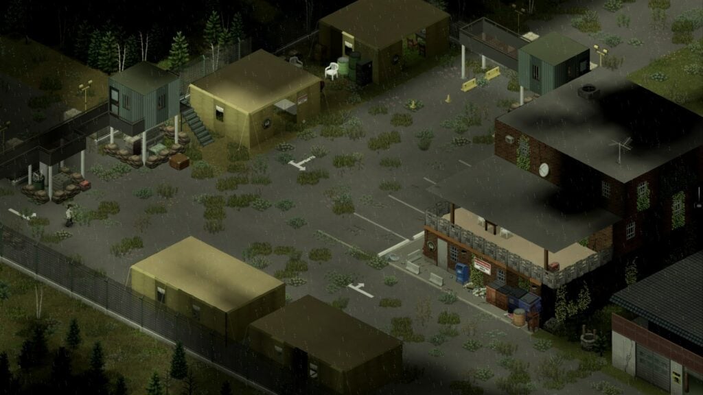 A green-hued empty parking lot at a fortified base. Grass grows across the asphalt.
